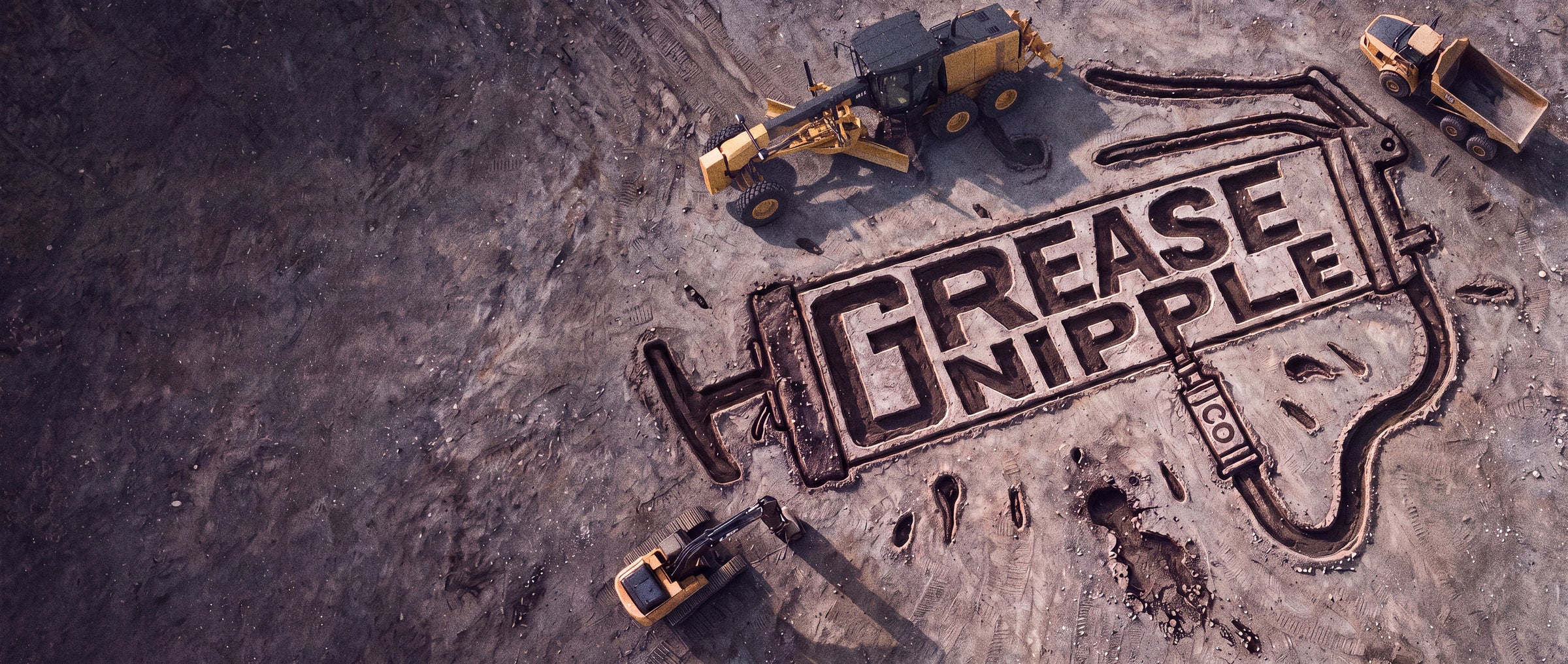 Heavy equipment surrounding the Grease Nipple Co. mark carved into quarry dirt